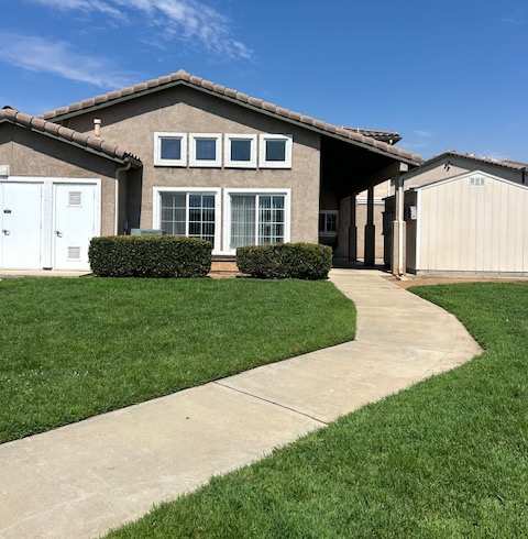 A house with a white garage door and a brown roof.