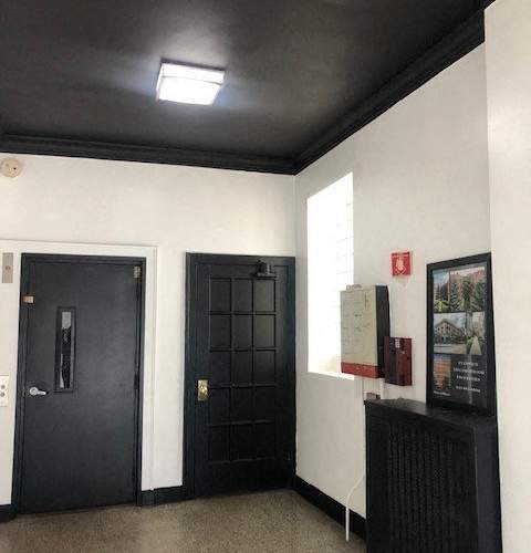 A black door with a handle and a window above it.