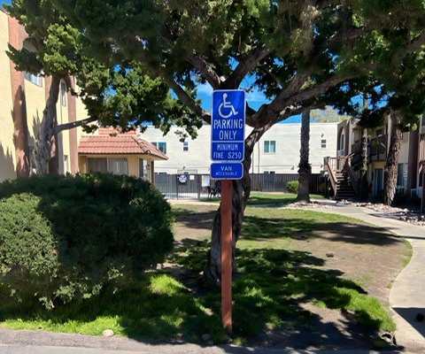 a blue handicapped parking sign in a parking lot