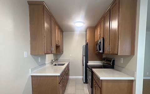 a kitchen with wooden cabinets and a stove and a refrigerator