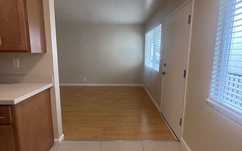 an empty kitchen with a door to a living room