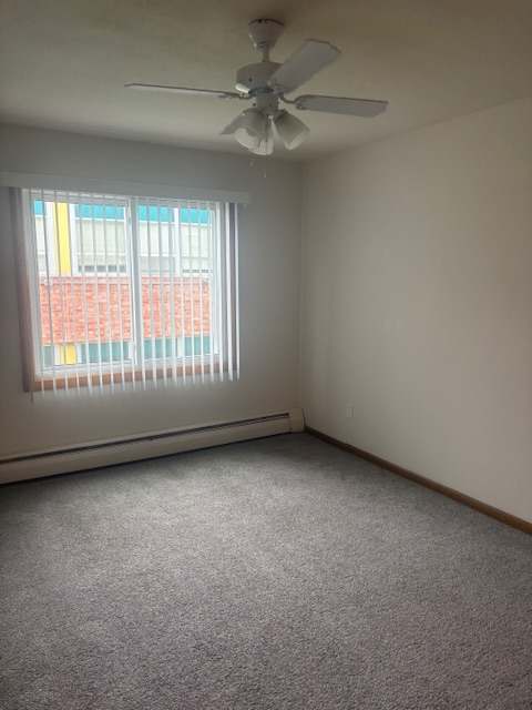 A window with blinds in a room with a ceiling fan.