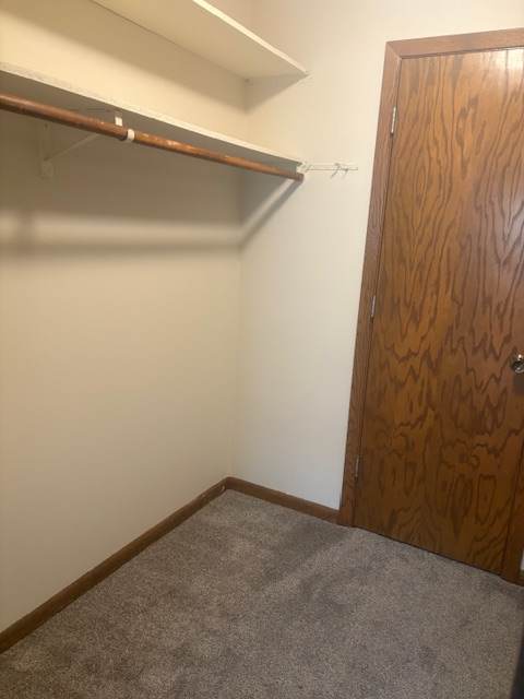 A brown wooden cabinet is above a white wall.