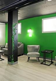 A room with a green wall and a grey chair.