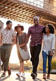 Four people walking together on a sunny day.