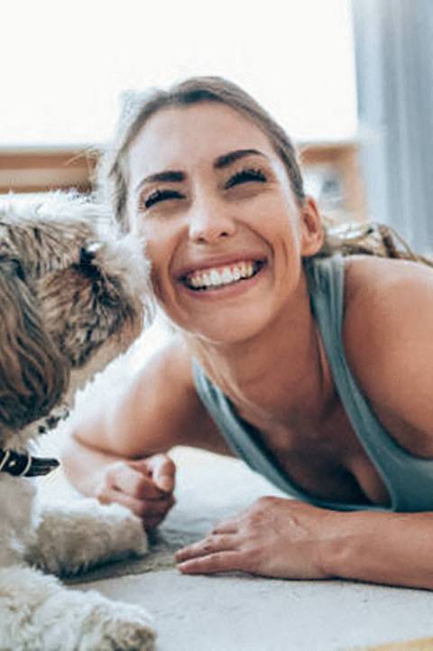 a woman laying on the floor next to a dog