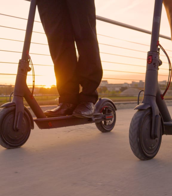 people riding scooters on a bridge at sunset at Link Apartments® CYKEL Apartments, Charlotte , NC