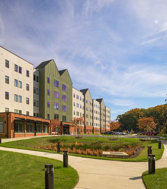 A modern building with a green roof and a walkway in front.