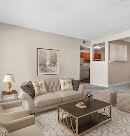 A living room with a couch, chairs, and a coffee table.
