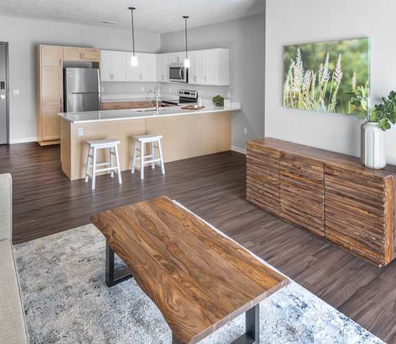A modern kitchen with a wooden island and bar stools.