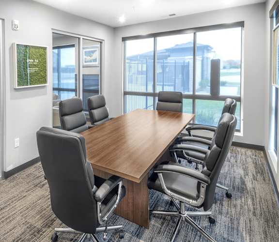 A conference room with a long table and chairs.