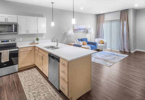 A modern kitchen with wooden cabinets and a white countertop.
