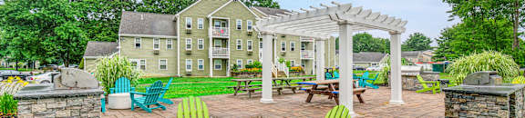 an outdoor patio with chairs and a pergola at Station Pointe, Mansfield, 02048