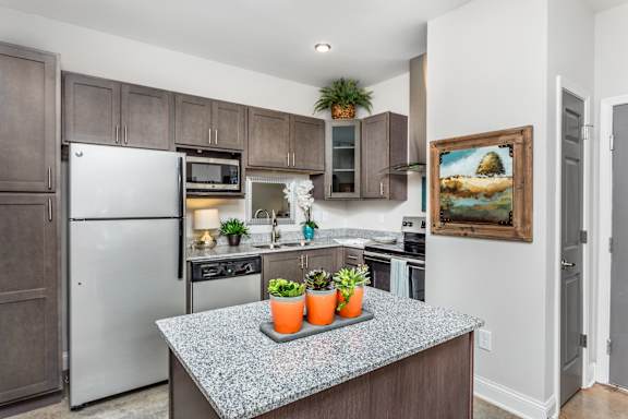 A kitchen with a wooden floor and a white wall.