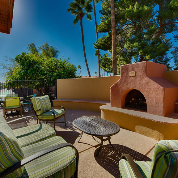 a backyard patio with a fireplace and furniture