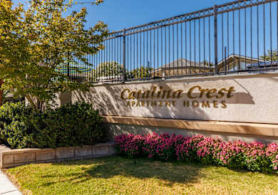 A sign that says "Crestline Crest Apartment Homes" is on a wall.