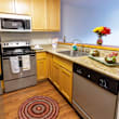 A kitchen with a refrigerator, oven, and microwave.