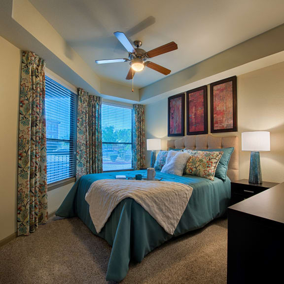 a bedroom with a large bed and a ceiling fan