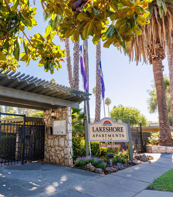 The image shows the entrance to Lakeshore Apartments with a signboard and a gate.
