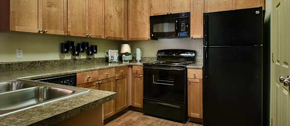 a kitchen with black appliances and wooden cabinets