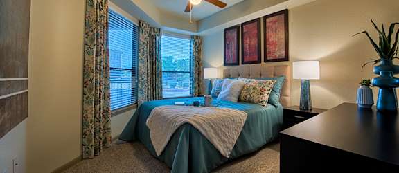 a bedroom with a large bed and a ceiling fan