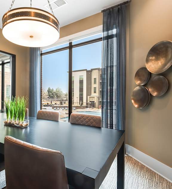 A modern dining room with a long table and chairs.