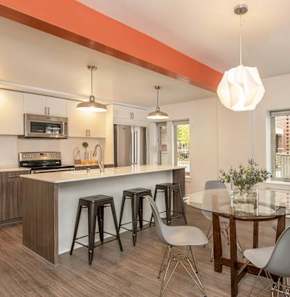 A kitchen with a bar and a dining table.