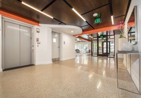 A hallway with a green exit sign above the door.