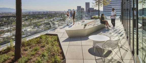 people on a roof terrace with a view of the city in the background