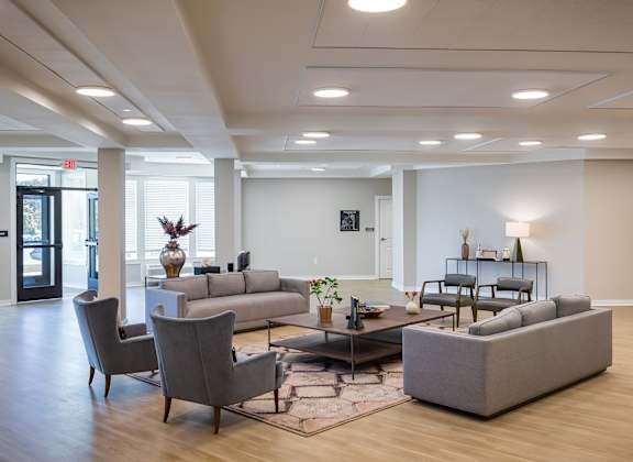A spacious living room with a grey sofa set and a coffee table.