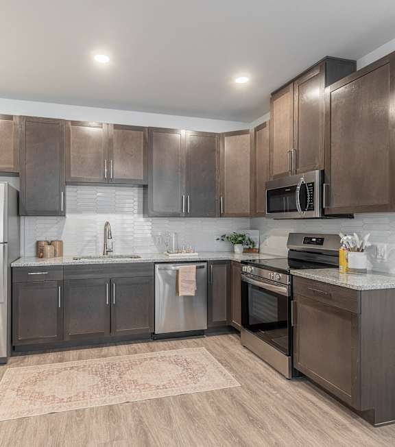 A modern kitchen with stainless steel appliances and wooden cabinets.