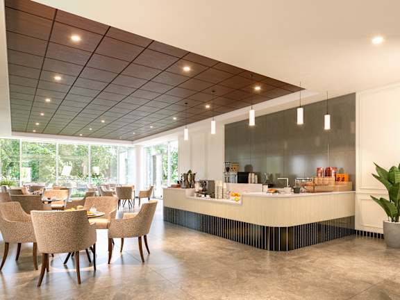A restaurant with a long counter and chairs.