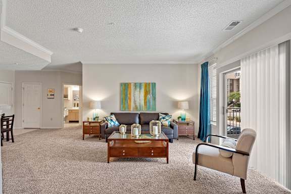 A living room with a grey couch, a wooden coffee table, and a painting on the wall.