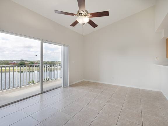 A room with a ceiling fan and sliding glass doors.