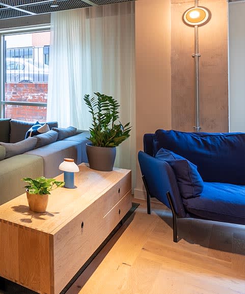 a living room with a blue couch and a wooden table