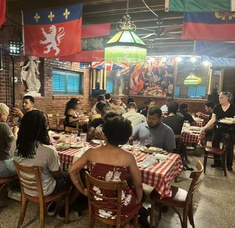 A group of people are sitting at tables in a restaurant.