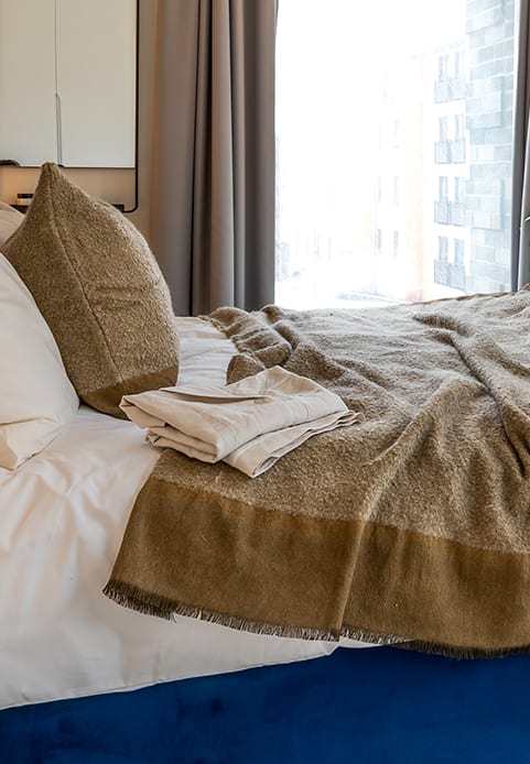 a bed with a blue headboard and pillows on it