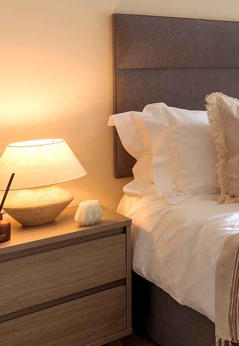 a bedroom with a large window and a bed with a blanket