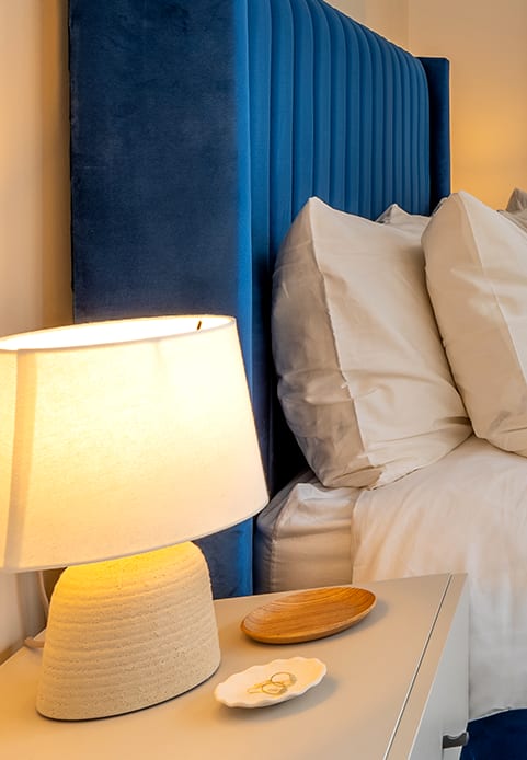 a bedroom with a large window and a bed with a blanket