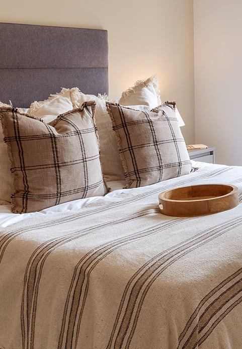 a bed with a blue headboard and pillows on it