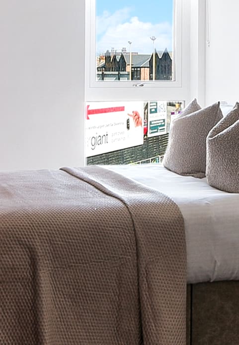 a bed with a blue headboard and pillows on it