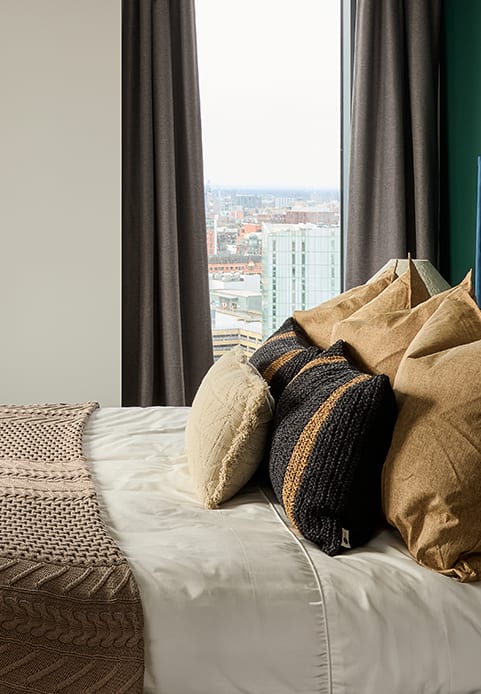 a bed with a blue headboard and pillows on it