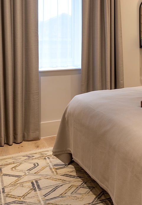 a bedroom with a large window and a bed with a blanket