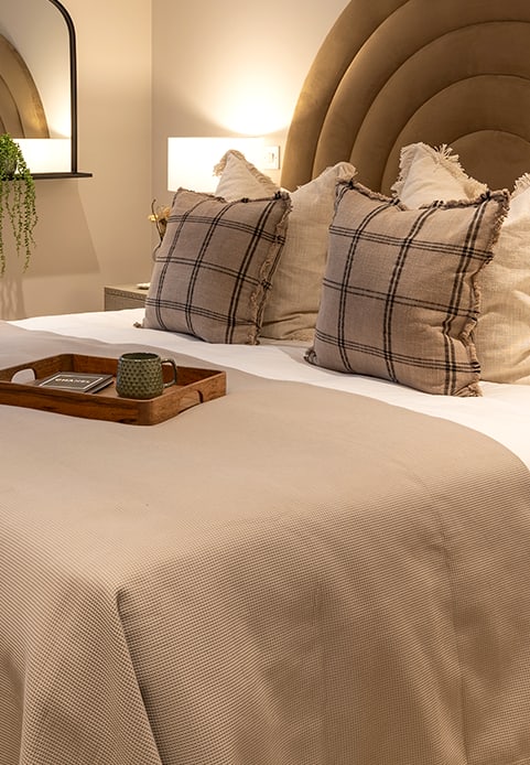 a bed with a blue headboard and pillows on it