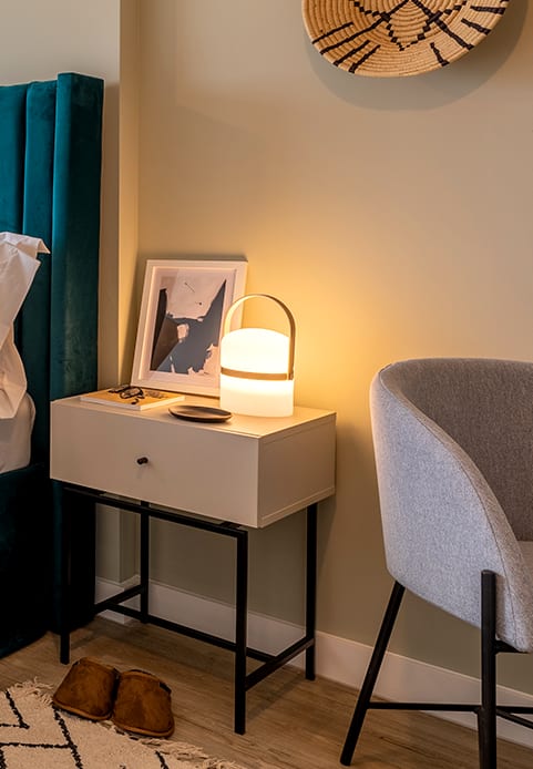 a desk with a lamp and a chair in a room