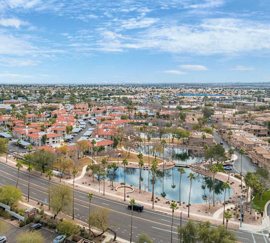 an aerial view of a city with a lake and cars on the street