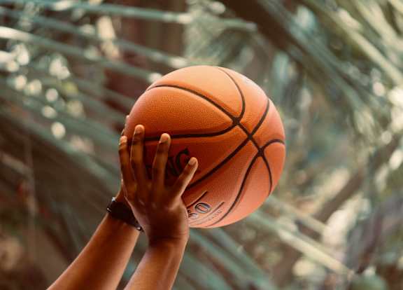 A person holding a basketball up to the camera.