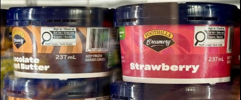Two containers of Foothills Creamy spreads, one chocolate peanut butter and the other strawberry.