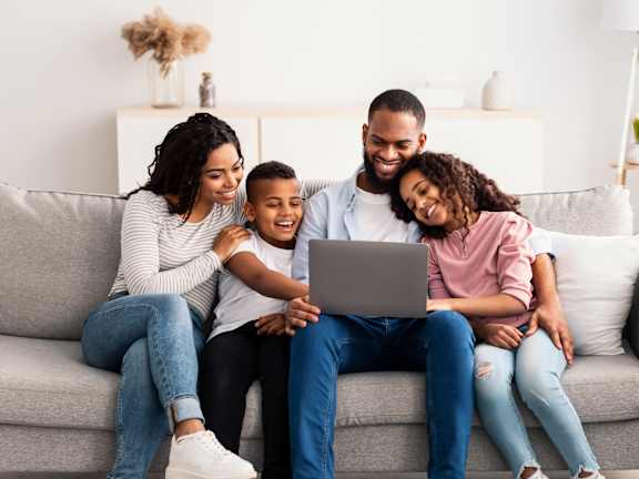 Family Sitting on a Couch at Station Heights Apartments in Alpharetta, GA, 30022