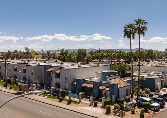 A street view of a residential area with houses and parked cars.